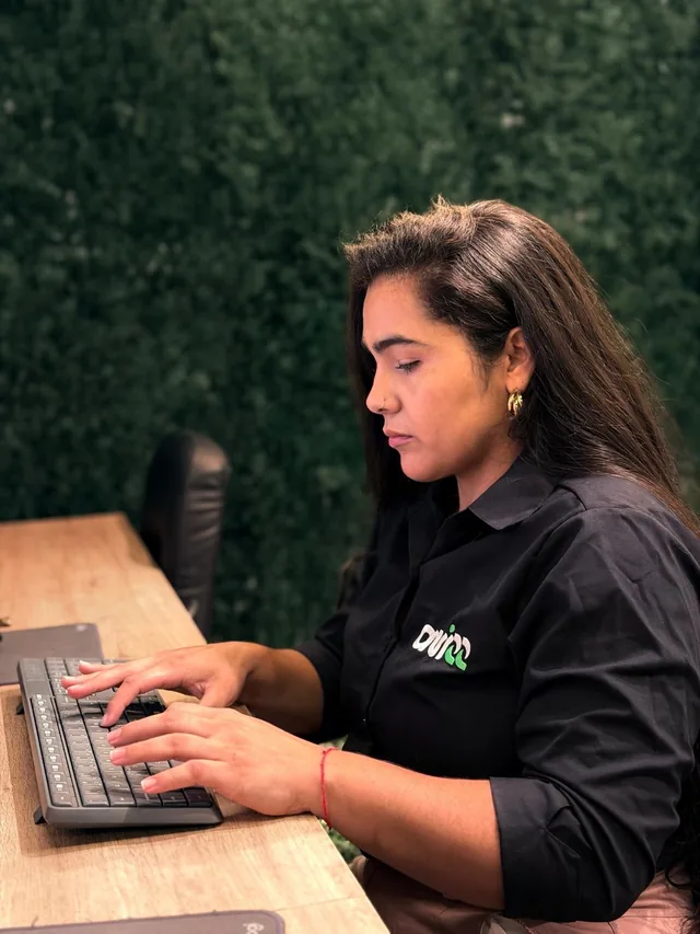 Profissional da Avizz com a camisa da empresa, trabalhando no computador na sede.